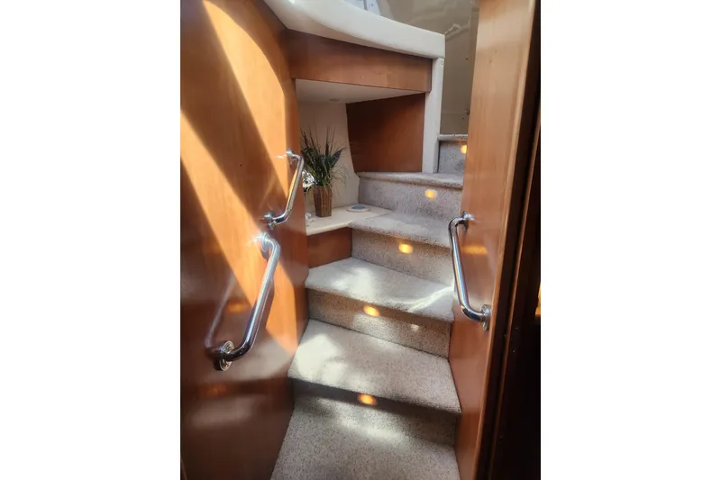Slide: The Image of Staircase inside 1998 Carver 530 Voyager Pilothouse yacht with wooden paneling and carpeted steps. - 21