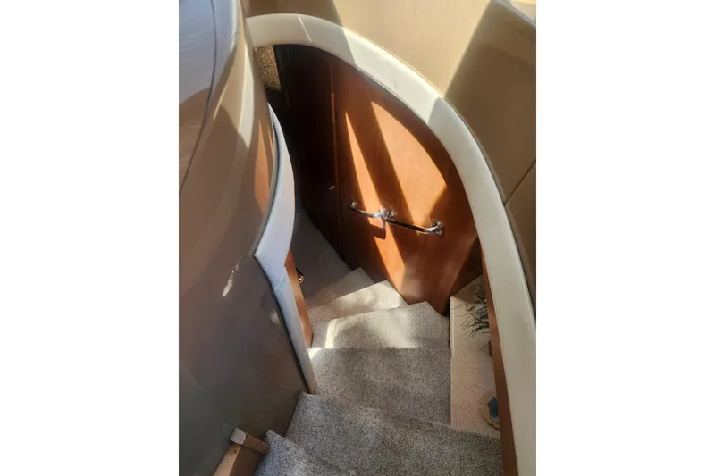 Slide: The Image of Staircase inside 1998 Carver 530 Voyager Pilothouse yacht, featuring carpeted steps and wooden handrail. - 3
