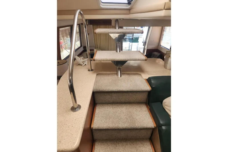 Slide: The Image of Staircase inside 1998 Carver 530 Voyager Pilothouse yacht with carpeted steps and metal railing. - 33