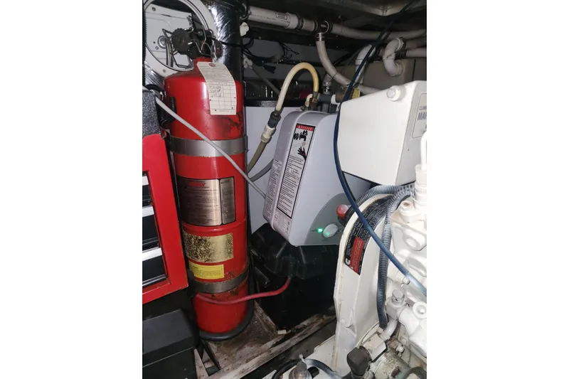 Slide: The Image of Engine room of 1998 Carver 530 Voyager Pilothouse with fire extinguisher and machinery. - 46