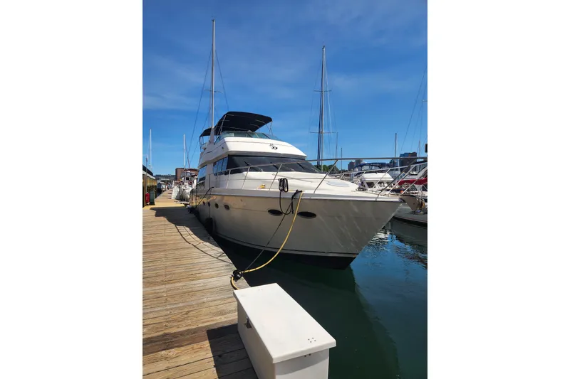 Slide: The Image of 1998 Carver 530 Voyager Pilothouse yacht docked at marina under clear blue sky. - 5