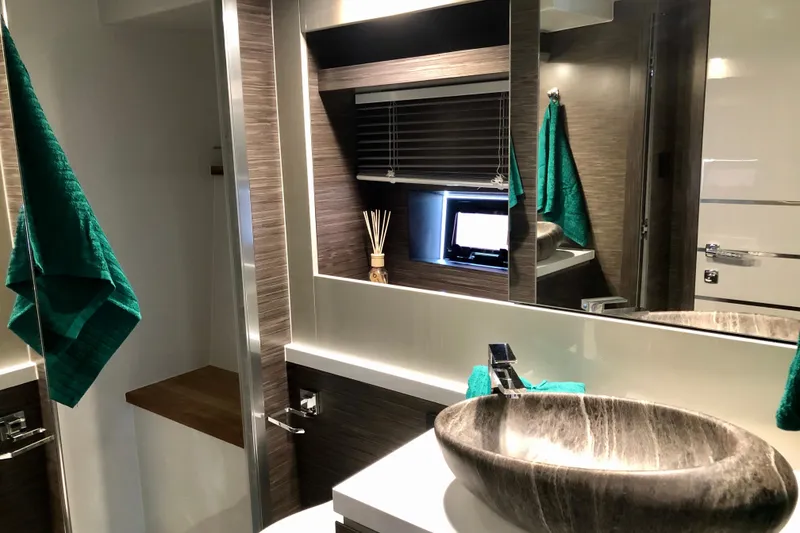 Slide: The Image of Luxurious bathroom interior of 2026 Cobrey 52 HT yacht with modern sink and green towels. - 15