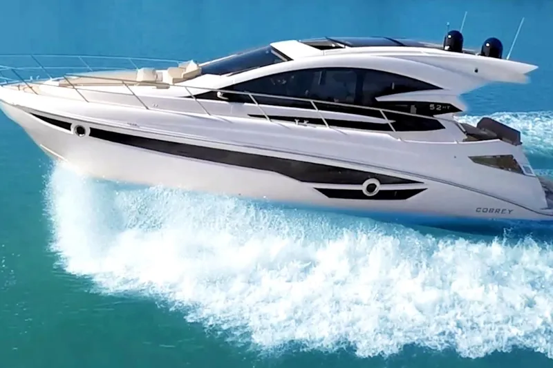 Slide: The Image of 2026 Cobrey 52 HT yacht cruising on clear blue water, showcasing sleek design and luxury. - 2