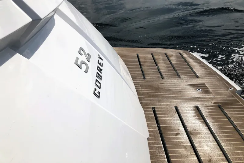Slide: The Image of 2026 Cobrey 52 HT yacht stern with teak deck and water view. - 3