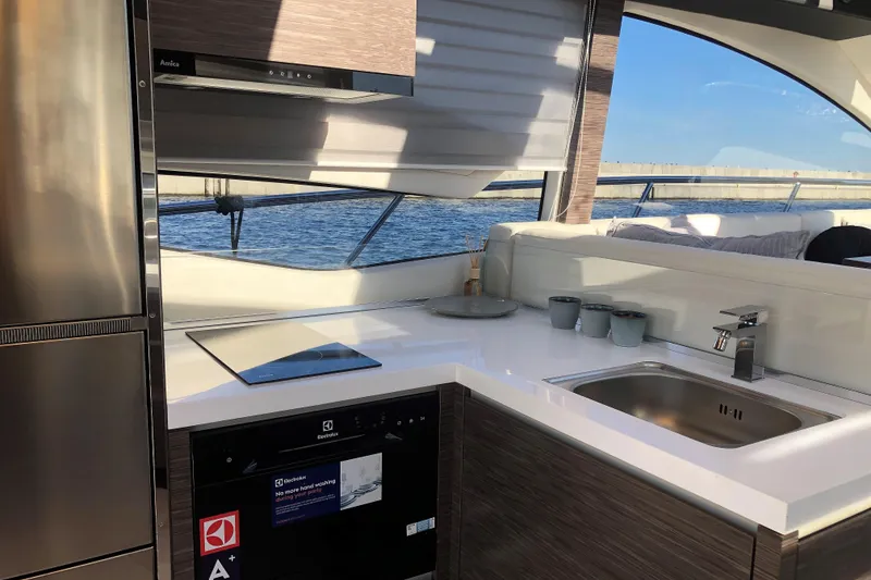 Slide: The Image of Modern kitchen interior on 2026 Cobrey 52 HT yacht with sleek appliances and ocean view. - 8