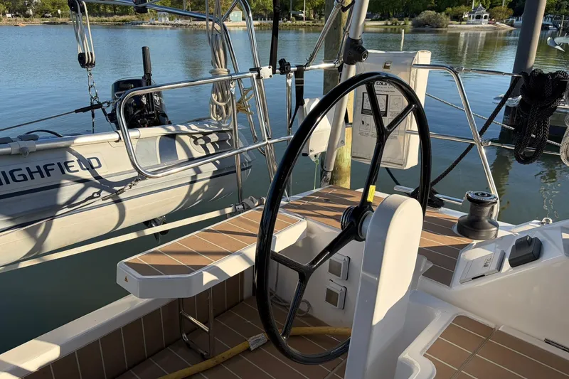 Slide: The Image of Cockpit of 2022 Bavaria C38 sailboat with steering wheel, docked near calm waters. - 10