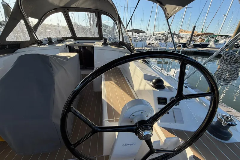 Slide: The Image of Cockpit view of 2022 Bavaria C38 yacht with steering wheel and marina background. - 11