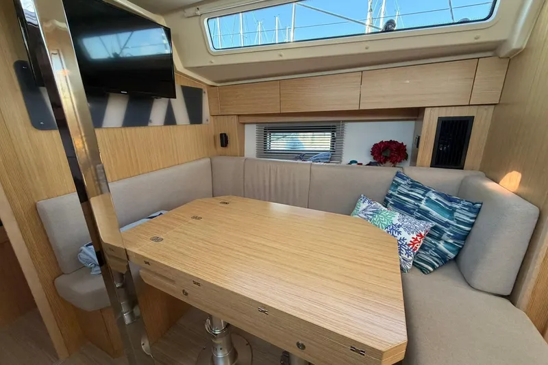 Slide: The Image of Cozy interior of 2022 Bavaria C38 yacht with wooden table and cushions. - 2