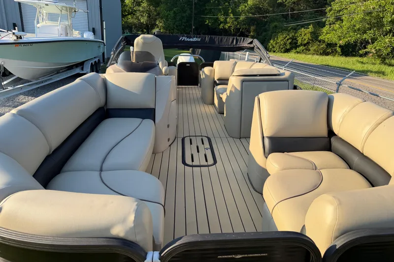 Slide: The Image of 2017 Manitou 25 Legacy pontoon boat with spacious beige seating and sleek design. - 16
