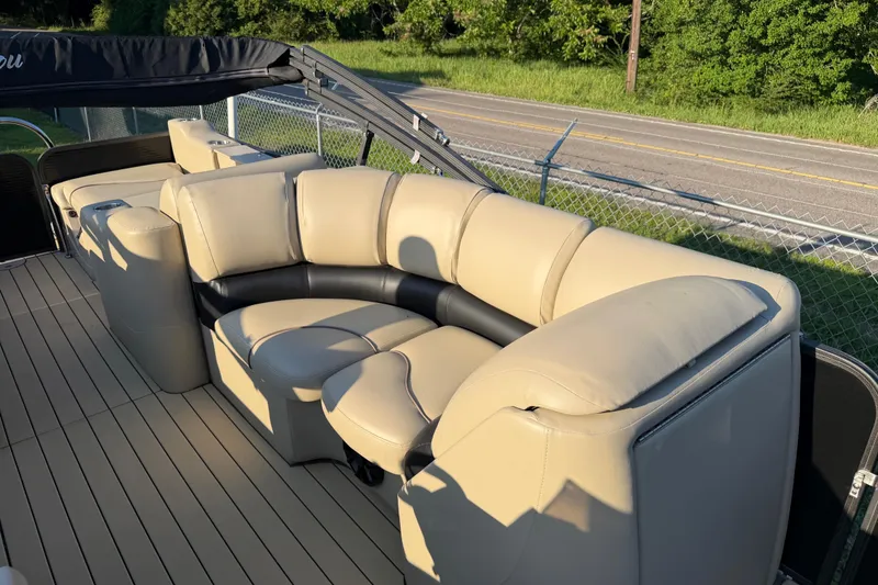 Slide: The Image of Luxurious seating on a 2017 Manitou 25 Legacy pontoon boat, featuring beige upholstery. - 18