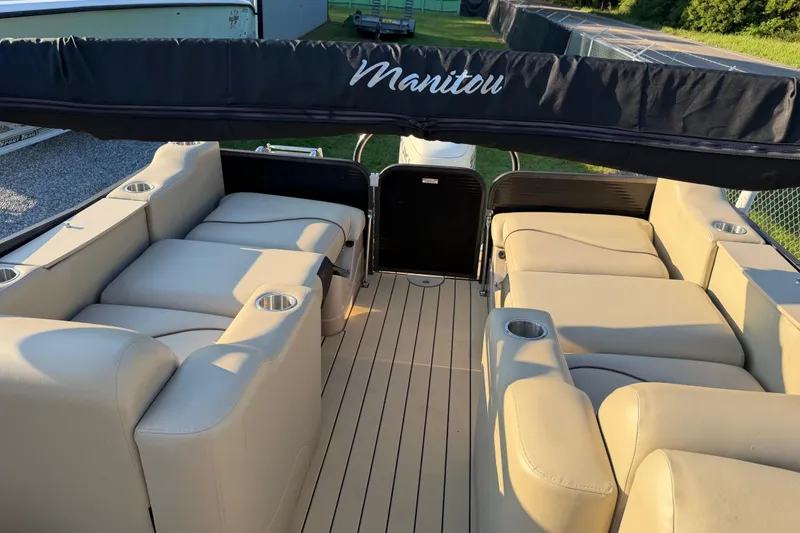 Slide: The Image of 2017 Manitou 25 Legacy pontoon boat with beige seating and cup holders. - 19