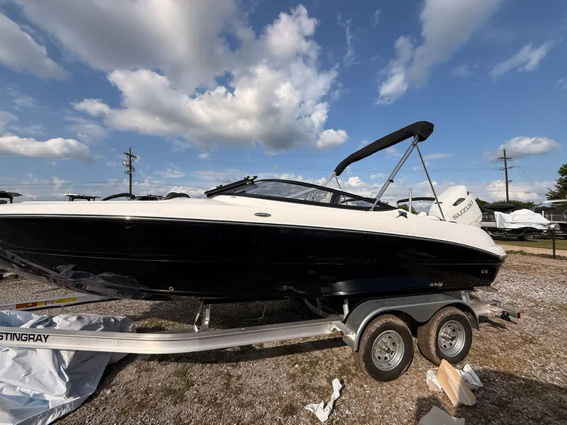 The Image of 2026 Stingray 23 OSX boat on trailer under blue sky. - 1