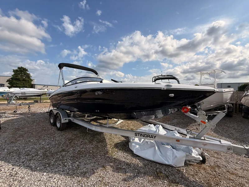 Slide: The Image of 2026 Stingray 23 OSX boat on trailer under blue sky. - 13
