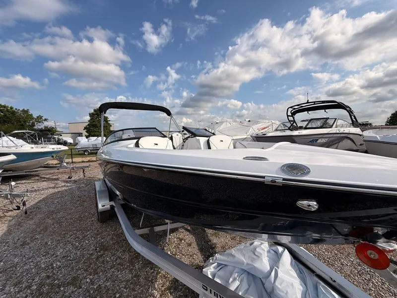 Slide: The Image of 2026 Stingray 23 OSX boat on a trailer under blue skies. - 3