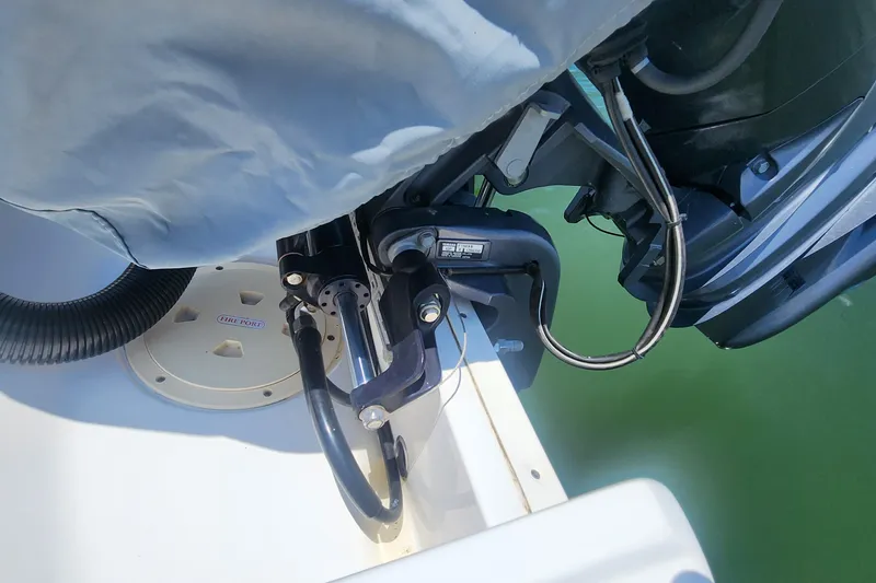 Slide: The Image of 2022 Chaparral 21 SSi OB boat engine detail with hydraulic components and water backdrop. - 10
