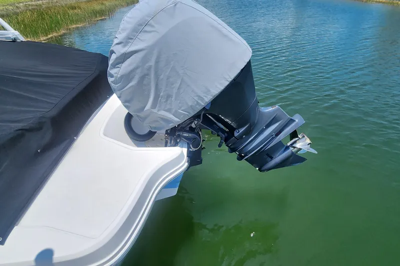 Slide: The Image of 2022 Chaparral 21 SSi OB boat with covered outboard motor on calm water. - 11