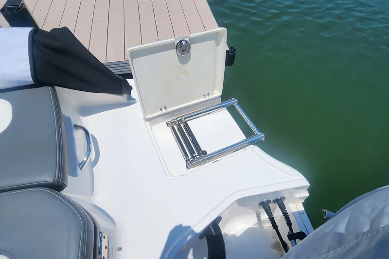 Slide: The Image of 2022 Chaparral 21 SSi OB boat with open swim ladder near dock. - 16