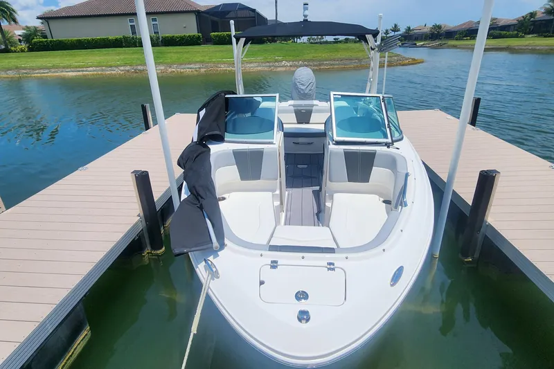 Slide: The Image of 2022 Chaparral 21 SSi OB boat docked on a sunny day, showcasing sleek design. - 18
