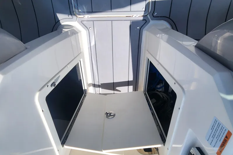 Slide: The Image of 2022 Chaparral 21 SSi OB boat interior storage compartments with open hatches. - 25