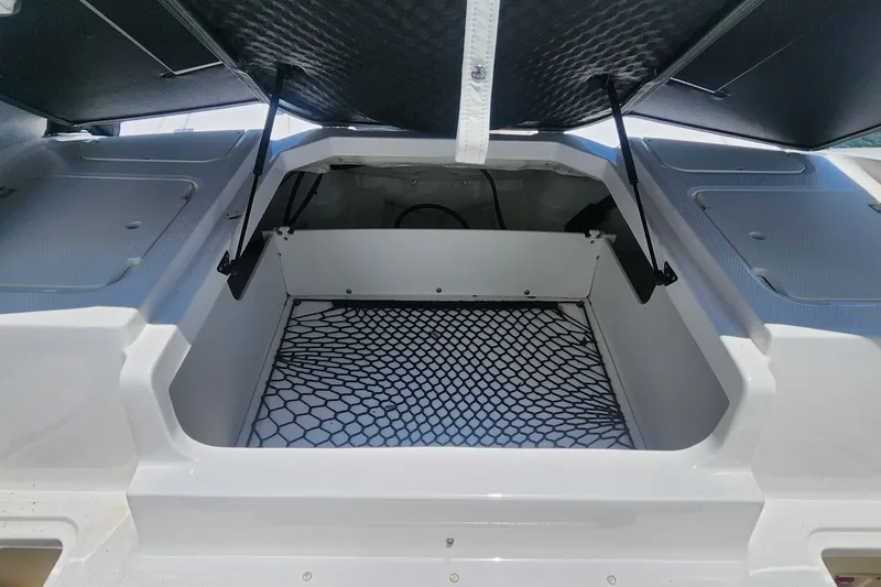 Slide: The Image of 2022 Chaparral 21 SSi OB boat storage compartment with open hatch and netted flooring. - 46