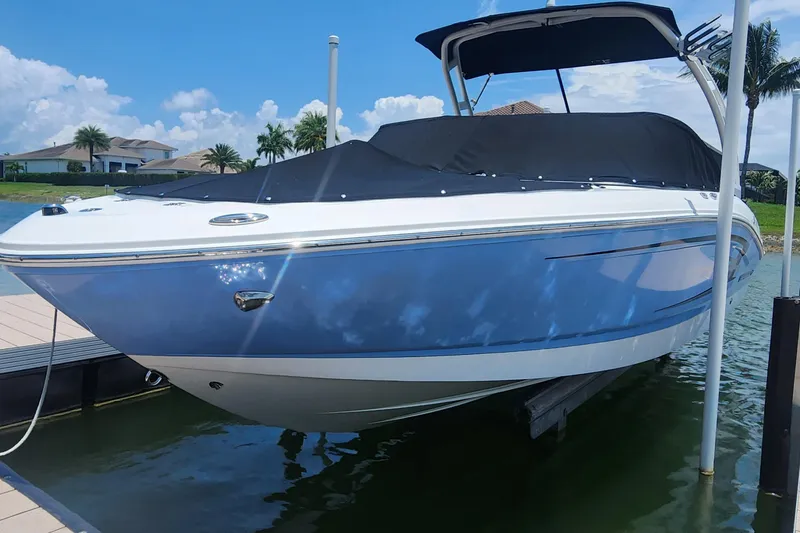 Slide: The Image of 2022 Chaparral 21 SSi OB boat docked on a sunny day, covered and ready for use. - 5