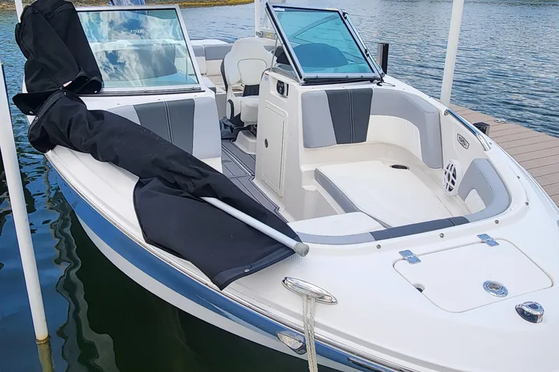 Slide: The Image of 2022 Chaparral 21 SSi OB boat docked, featuring sleek design and spacious seating. - 51