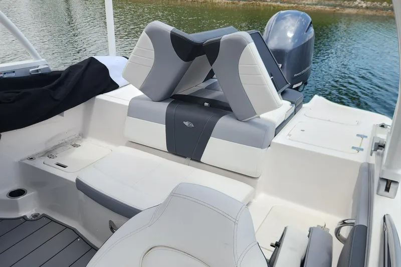 Slide: The Image of 2022 Chaparral 21 SSi OB boat interior with seating and outboard motor on water. - 56