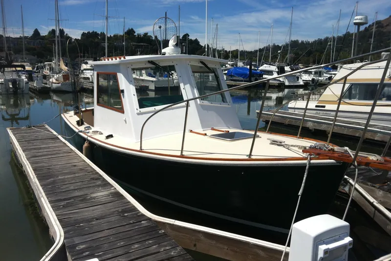 Slide: The Image of 1974 Dyer 29' Sport Fisher boat docked in a marina, surrounded by other vessels. - 14