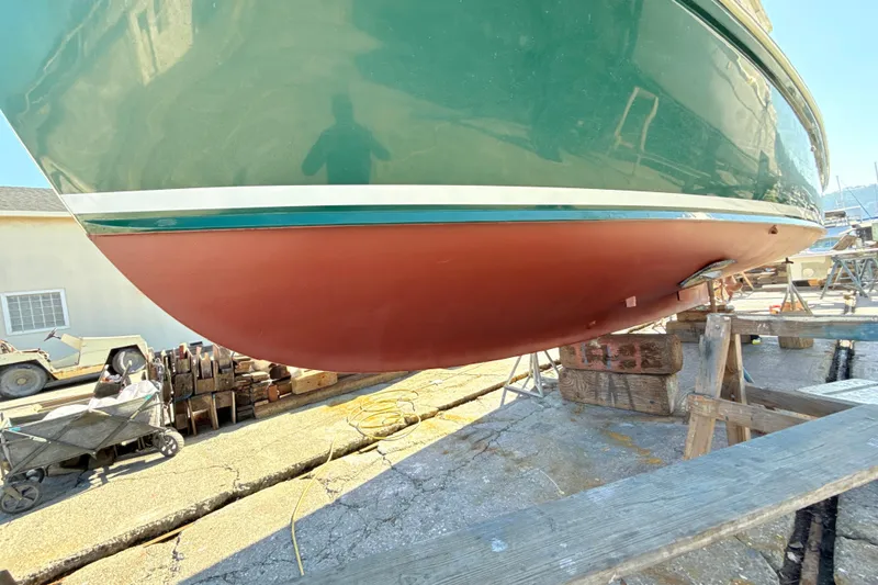 Slide: The Image of 1974 Dyer 29' Sport Fisher boat on dry dock, green and red hull visible. - 16