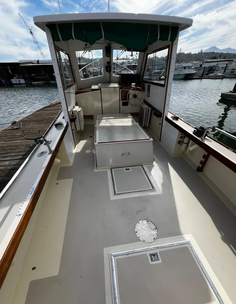 Slide: The Image of 1974 Dyer 29' Sport Fisher boat with spacious deck and marina backdrop. - 25