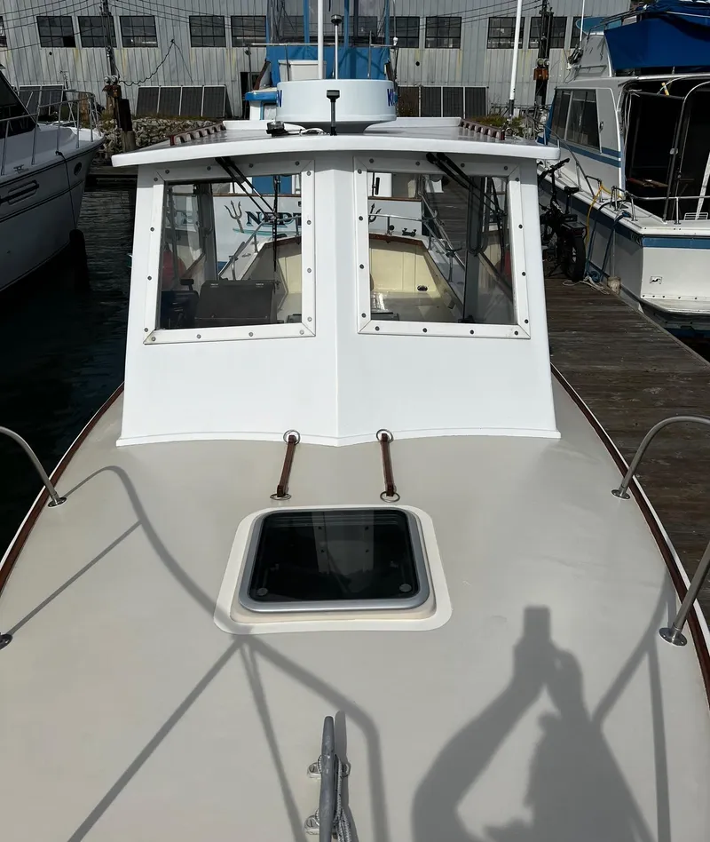 Slide: The Image of 1974 Dyer 29' Sport Fisher boat docked, showcasing cabin and deck features. - 26