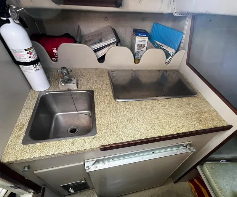 Slide: The Image of 1974 Dyer 29' Sport Fisher galley with sink, countertop, and storage. - 28