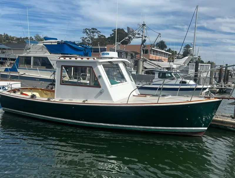 Slide: The Image of 1974 Dyer 29' Sport Fisher boat docked at a marina under a cloudy sky. - 4