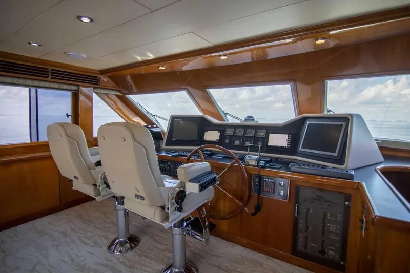 Slide: The Image of Luxurious helm of 2001 Hargrave 94 yacht with dual captain chairs and advanced navigation systems. - 13