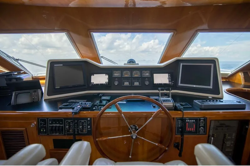 Slide: The Image of Helm of 2001 Hargrave 94 yacht with navigation screens and wooden steering wheel. - 14