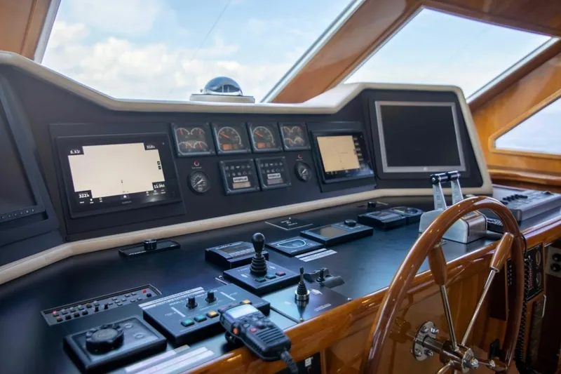 Slide: The Image of Cockpit of a 2001 Hargrave 94 yacht with navigation instruments and wooden steering wheel. - 15