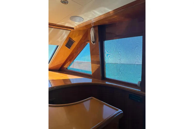 Slide: The Image of Interior view of 2001 Hargrave 94 yacht with wooden finish and ocean view through windows. - 16