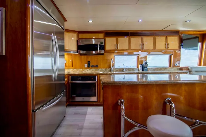 Slide: The Image of Luxurious kitchen interior on a 2001 Hargrave 94 yacht, featuring modern appliances and elegant wood finishes. - 27