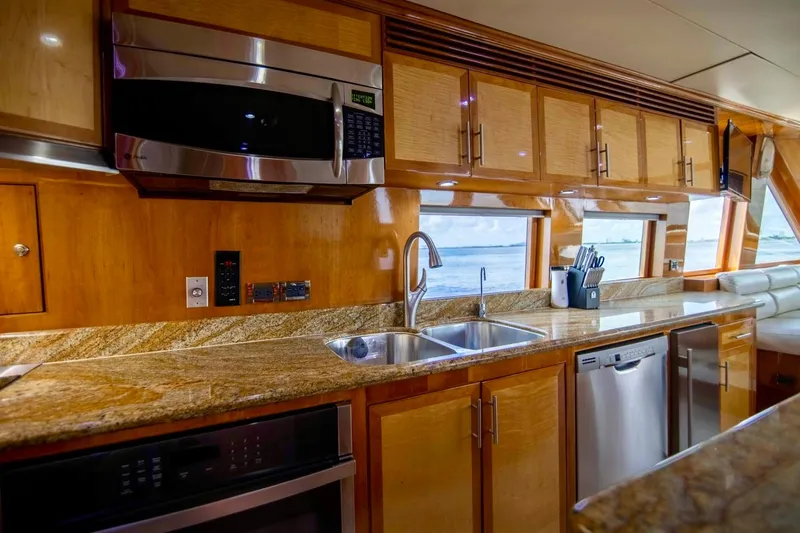 Slide: The Image of Luxurious kitchen interior on 2001 Hargrave 94 yacht with granite countertops and stainless steel appliances. - 28