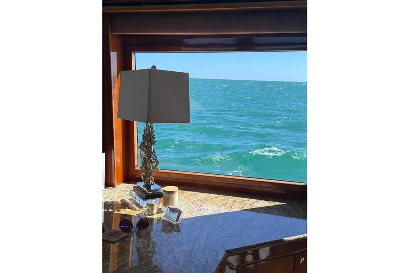 Slide: The Image of Luxurious yacht interior with ocean view, featuring elegant lamp and decor on marble surface. - 44
