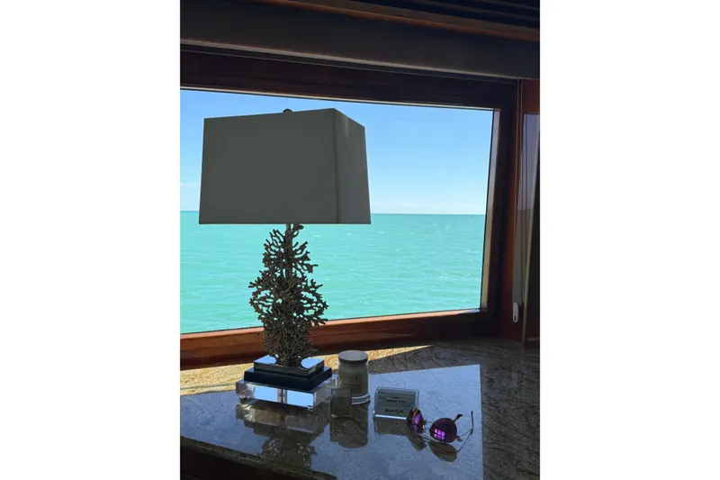 Slide: The Image of Luxurious yacht interior with ocean view, featuring a decorative lamp and sunglasses on a table. - 45