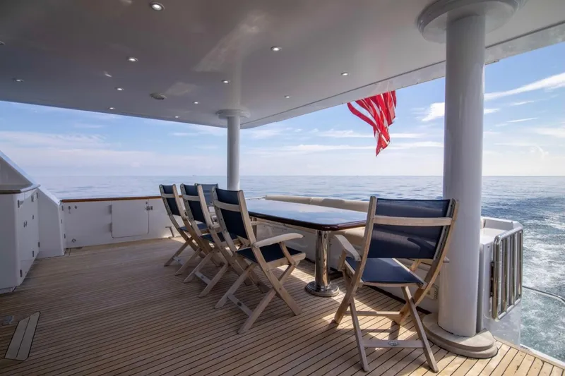 Slide: The Image of Deck of 2001 Hargrave 94 yacht with seating, ocean view, and American flag. - 49