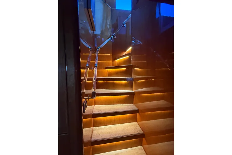 Slide: The Image of Illuminated wooden staircase with metal railings inside a 2001 Hargrave 94 yacht. - 52