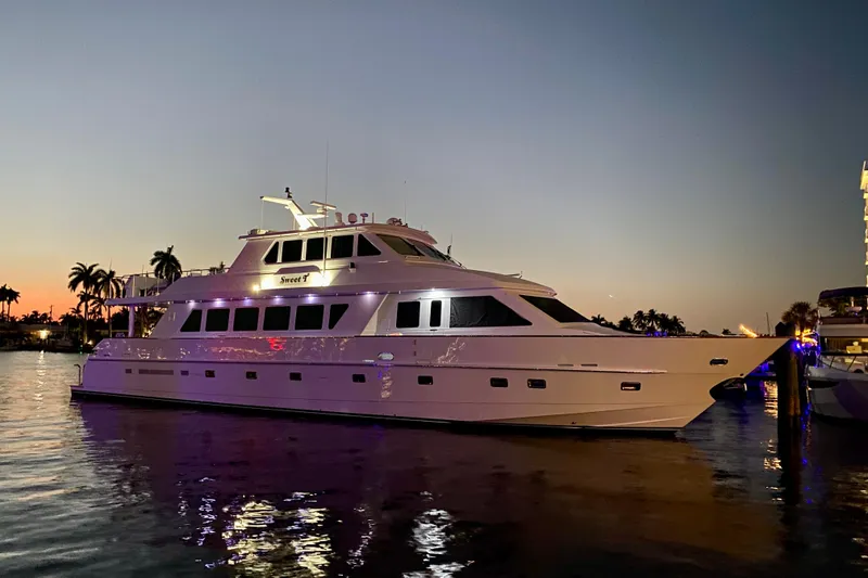Slide: The Image of Luxurious 2001 Hargrave 94 yacht docked at sunset, reflecting on calm water. - 6