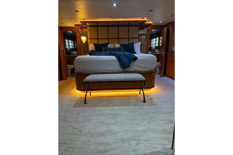 Slide: The Image of Luxurious bedroom interior on a 2001 Hargrave 94 yacht, featuring elegant lighting and plush bedding. - 61