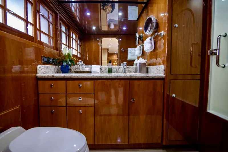 Slide: The Image of Luxurious bathroom in a 2001 Hargrave 94 yacht, featuring elegant wood cabinetry and granite countertops. - 64