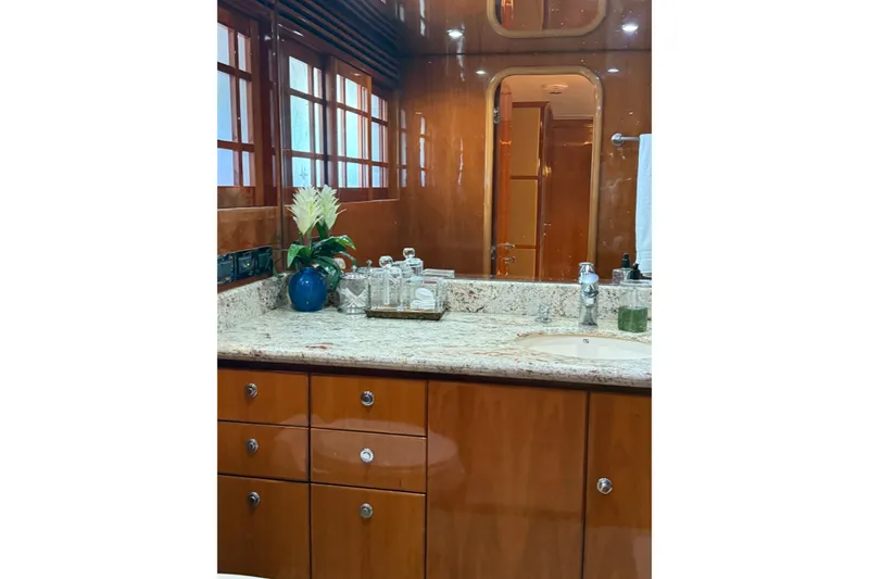 Slide: The Image of Luxurious bathroom interior on a 2001 Hargrave 94 yacht, featuring wood cabinetry and granite countertop. - 65