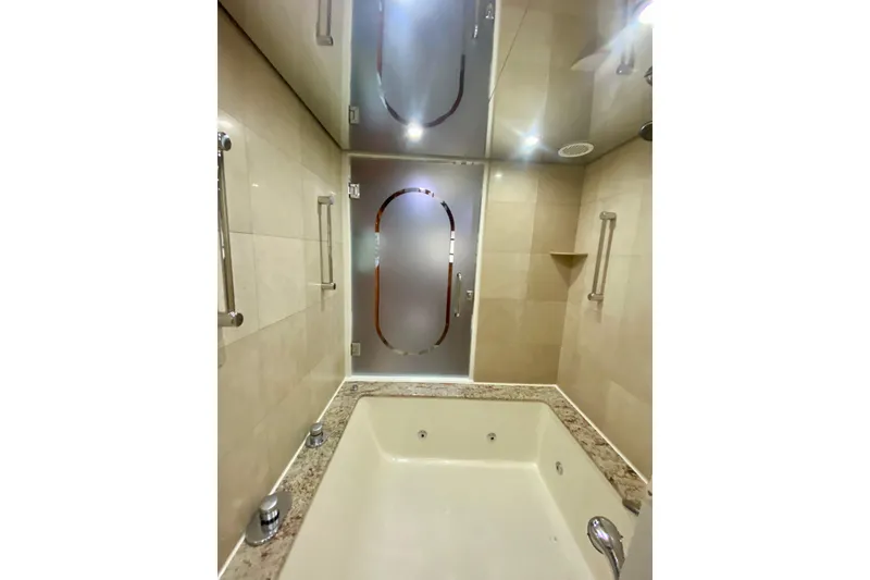 Slide: The Image of Luxurious bathroom with a marble tub and frosted glass door on a 2001 Hargrave 94 yacht. - 69