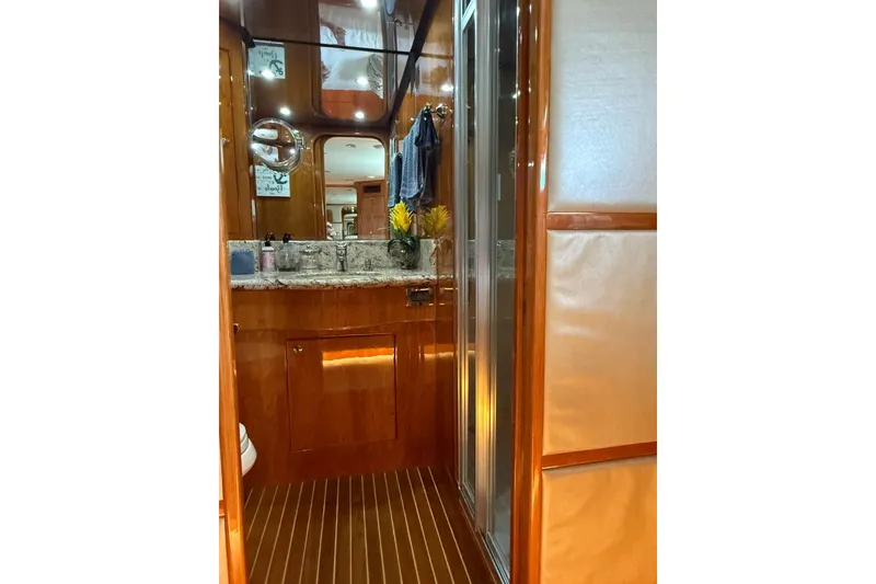 Slide: The Image of Luxurious bathroom interior on a 2001 Hargrave 94 yacht, featuring wood finishes and granite countertop. - 74