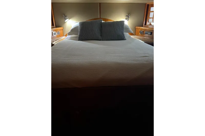 Slide: The Image of Luxurious bedroom interior on a 2001 Hargrave 94 yacht, featuring elegant bedding and ambient lighting. - 79
